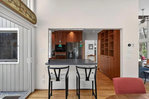 a view of a hallway with wooden floor and cabinet