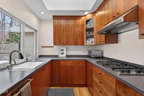 a kitchen with wooden cabinets and a stove top oven