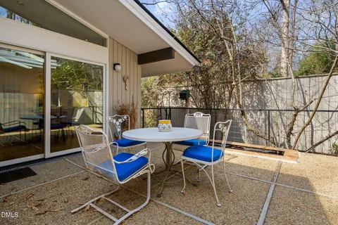 a backyard of a house with table and chairs