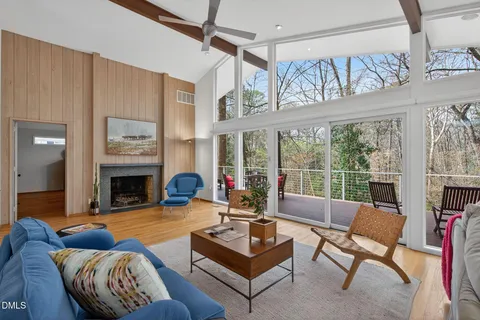 a living room with furniture large window and a fireplace