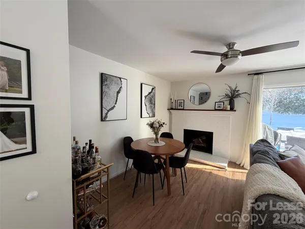 a living room with furniture a fireplace and wooden floor