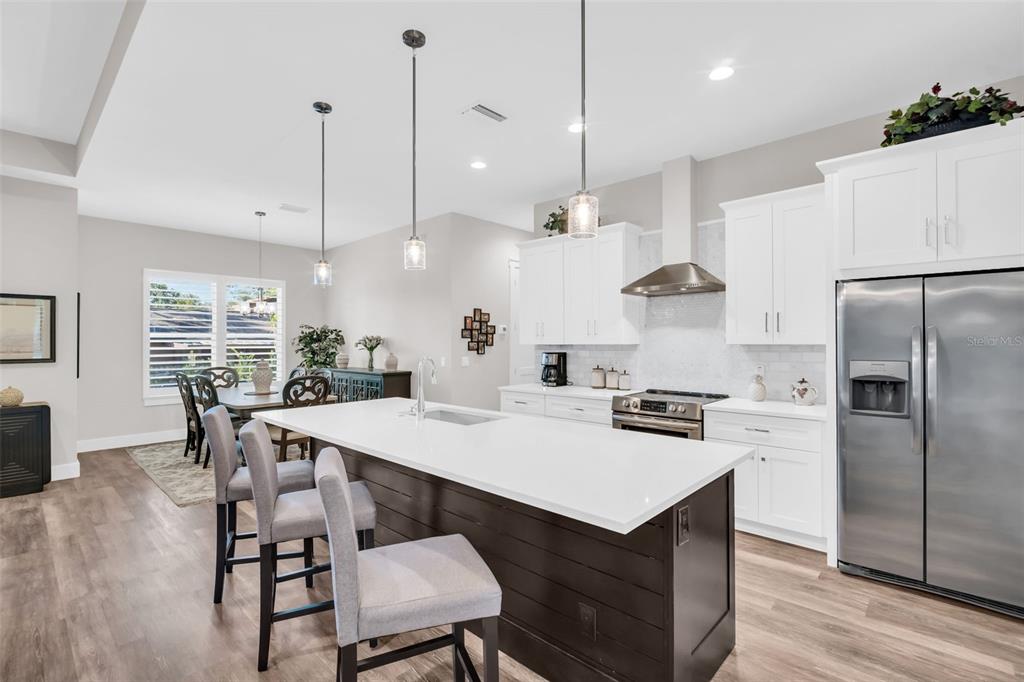 9840 West Bay Street Seminole, FL 33776 - Photo 11 of 75 a kitchen with a dining table chairs refrigerator and microwave