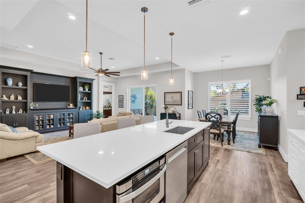 9840 West Bay Street Seminole, FL 33776 - Photo 12 of 75 a large kitchen with kitchen island a sink a counter space and living room view