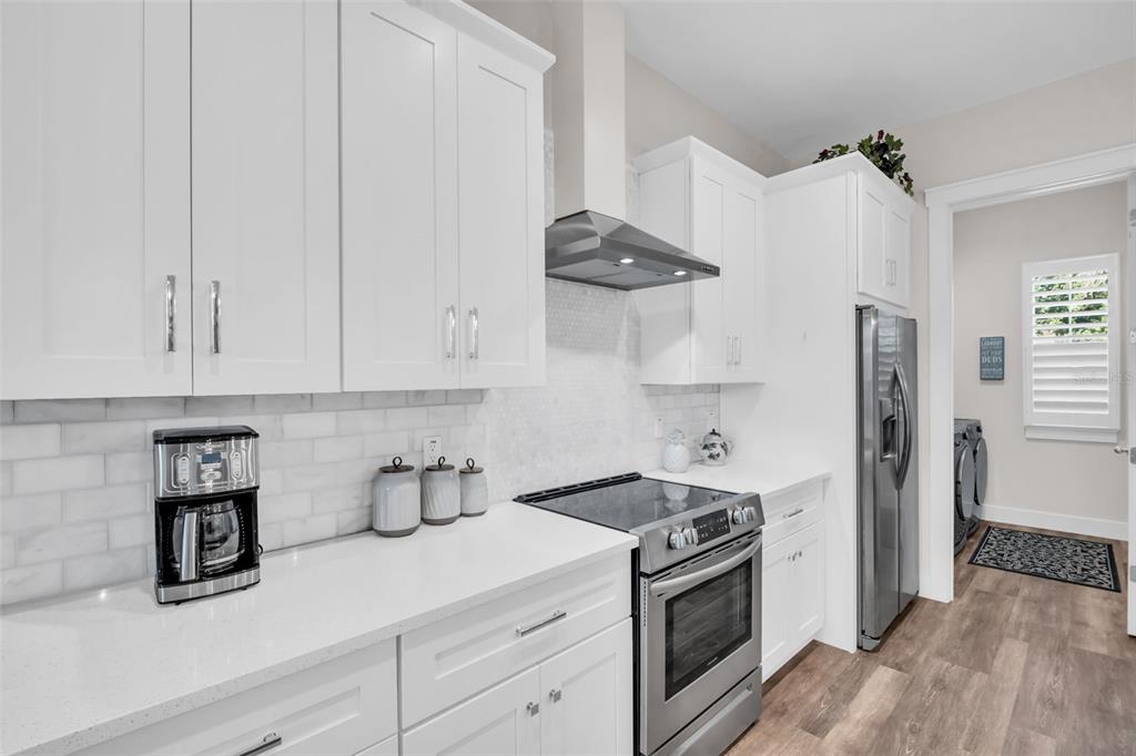 9840 West Bay Street Seminole, FL 33776 - Photo 15 of 75 a kitchen with stainless steel appliances granite countertop a sink a stove and a refrigerator