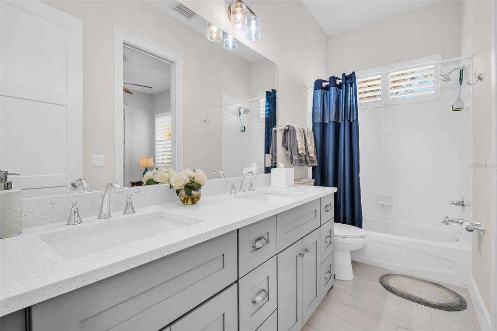 9840 West Bay Street Seminole, FL 33776 - Photo 31 of 75 a bathroom with a double vanity sink toilet mirror and bathtub