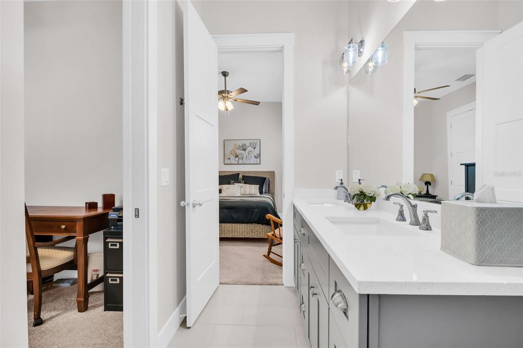 9840 West Bay Street Seminole, FL 33776 - Photo 32 of 75 a en suite bathroom with a double vanity sink and a mirror