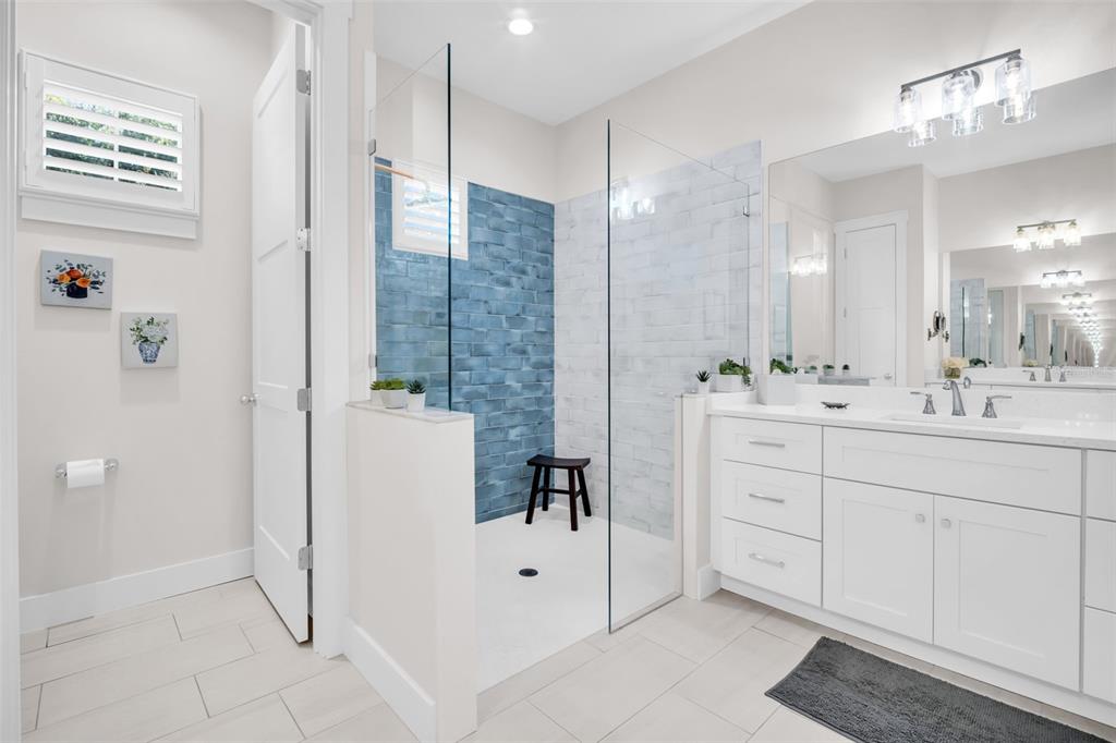 9840 West Bay Street Seminole, FL 33776 - Photo 44 of 75 a bathroom with a double vanity sink mirror and shower