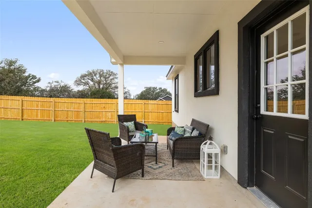a view of a patio with couches chairs potted plants and ocean view