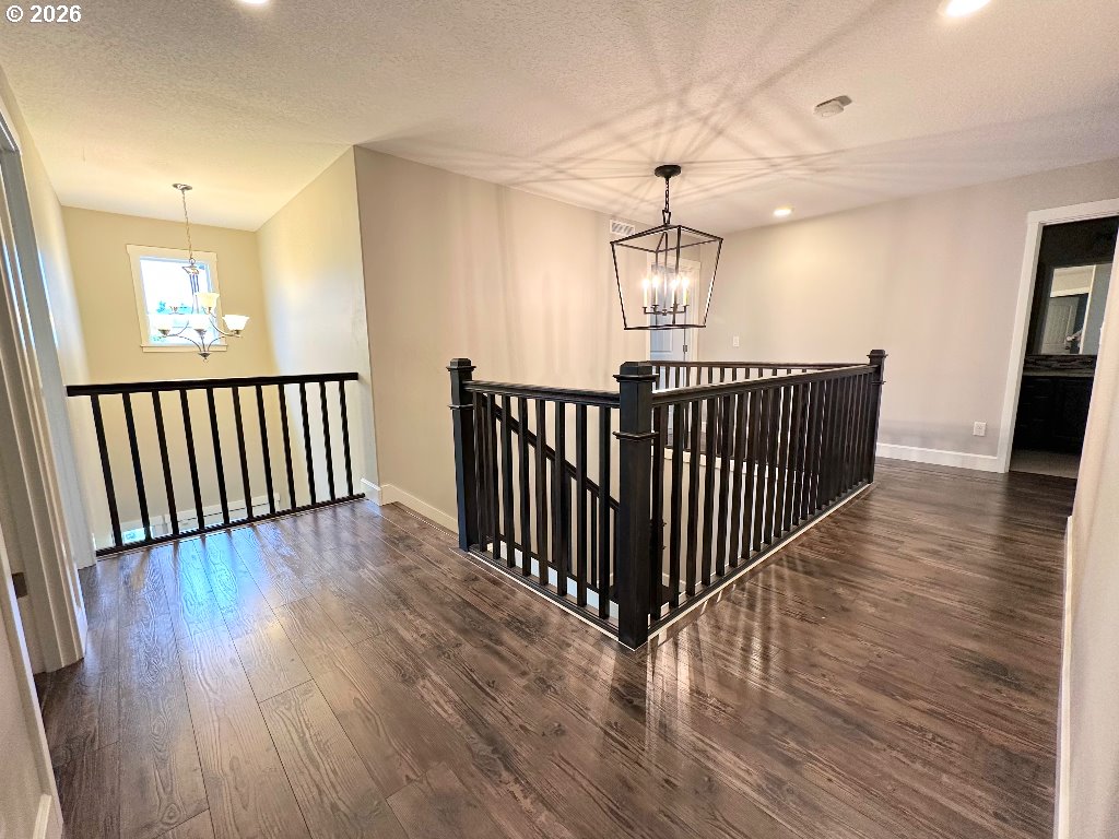 885 North Squire Drive Ridgefield, WA 98642 - Photo 23 of 29 an empty room with wooden floor windows and a chandelier