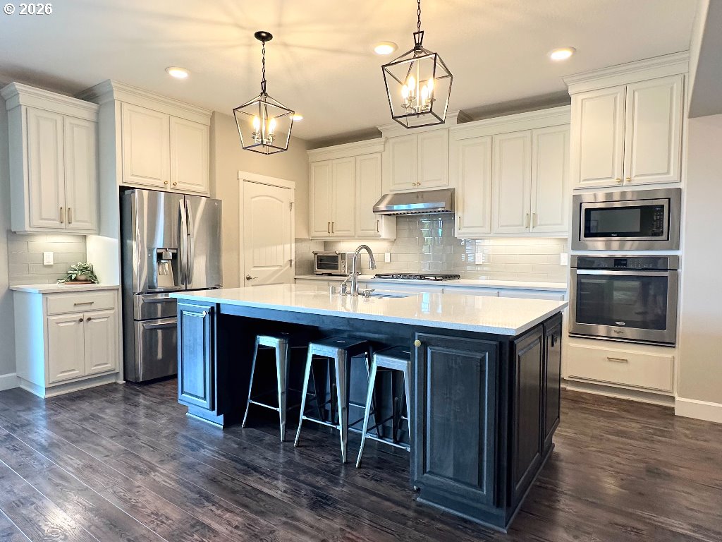885 North Squire Drive Ridgefield, WA 98642 - Photo 4 of 29 a kitchen with wooden cabinets and stainless steel appliances