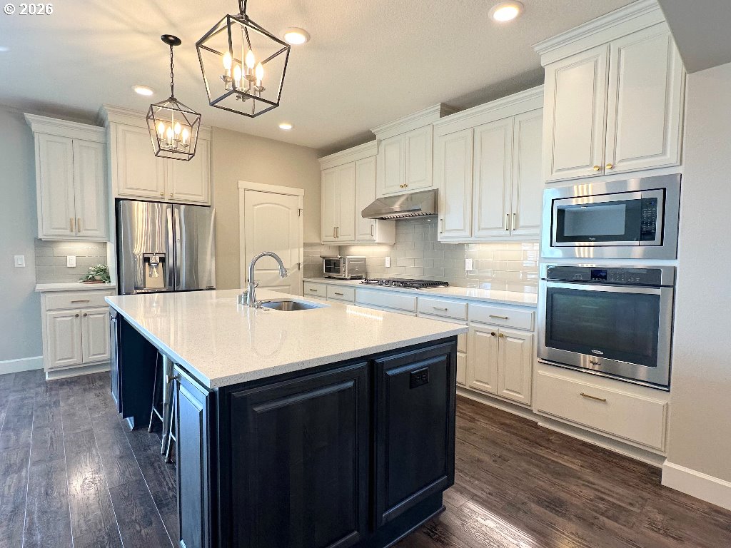 885 North Squire Drive Ridgefield, WA 98642 - Photo 5 of 29 a kitchen with a sink a microwave a stove and cabinets