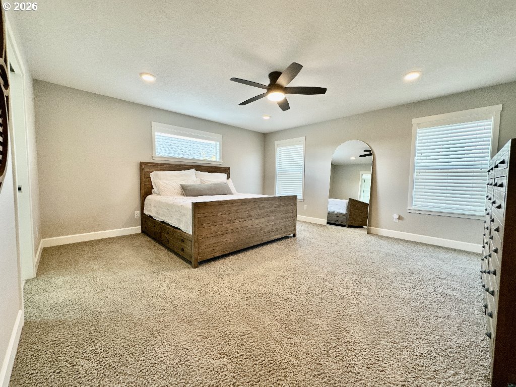 885 North Squire Drive Ridgefield, WA 98642 - Photo 10 of 29 a spacious bedroom with a bed and a chandelier