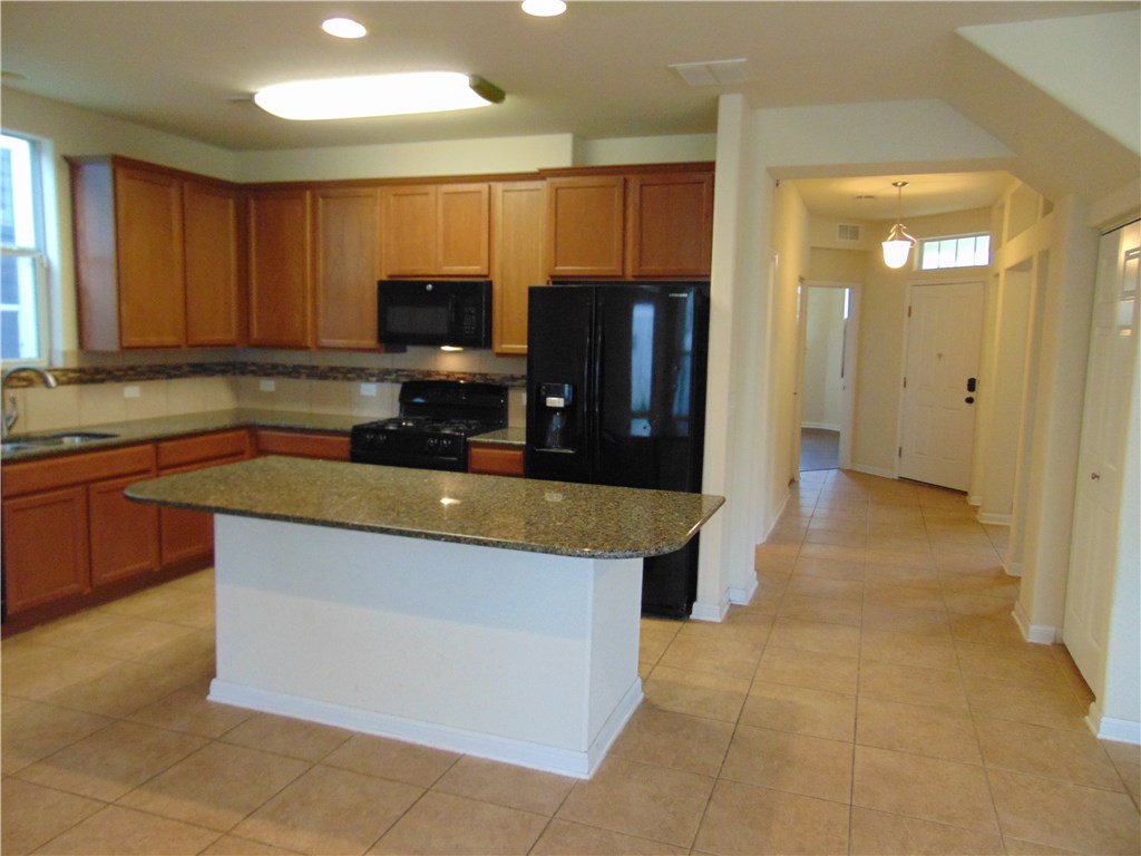 5208 Hellman Kyle, TX 78640 - Photo 5 of 26 a kitchen with stainless steel appliances granite countertop a stove a sink and a refrigerator