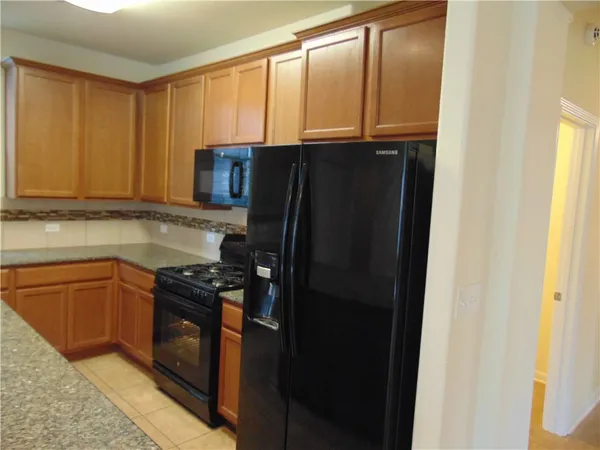 a kitchen with granite countertop cabinets and refrigerator