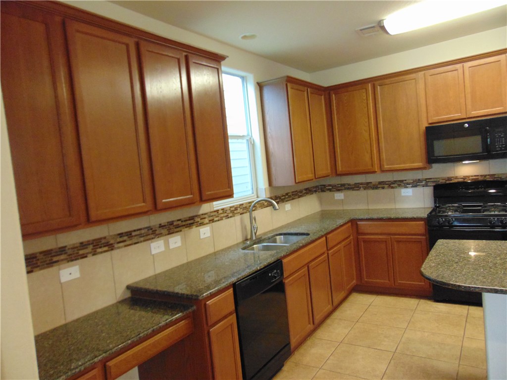 5208 Hellman Kyle, TX 78640 - Photo 9 of 26 a kitchen with stainless steel appliances granite countertop a sink stove and cabinets