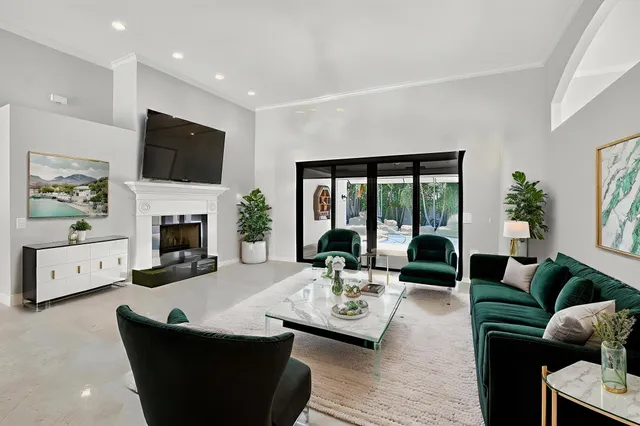 an empty room with windows chandelier and fireplace