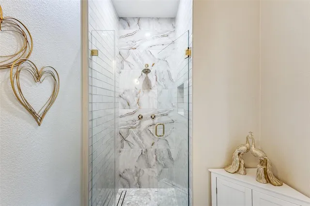 a bathroom with a granite countertop sink a mirror and shower