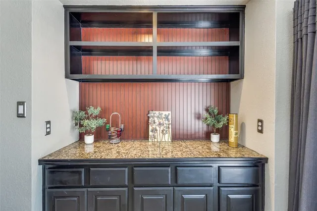 a kitchen with granite countertop a table chair and cabinets