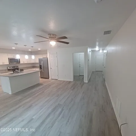a large kitchen with a stove top oven and white cabinets
