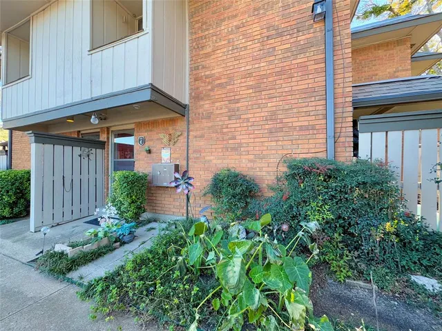 a backyard of a house with plants and outdoor seating