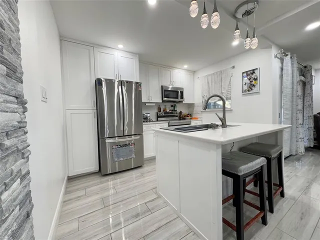 a kitchen with refrigerator and cabinets