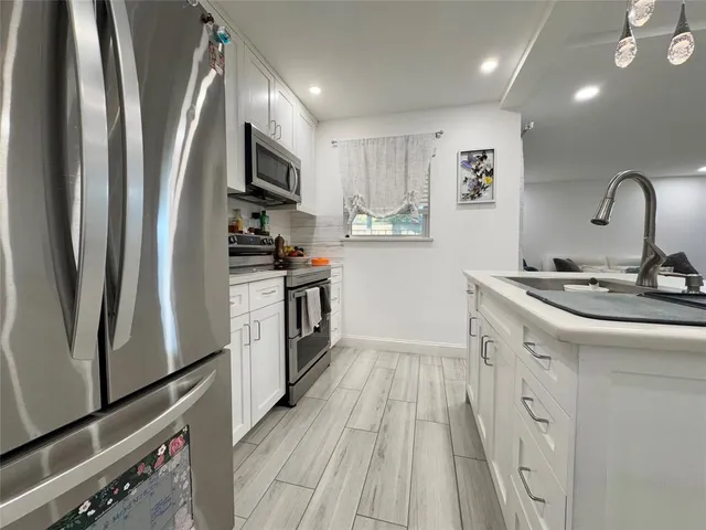 a kitchen with stainless steel appliances a refrigerator sink and microwave