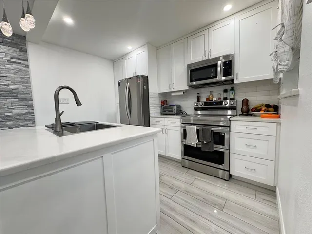 a kitchen with stainless steel appliances a stove cabinets and a sink