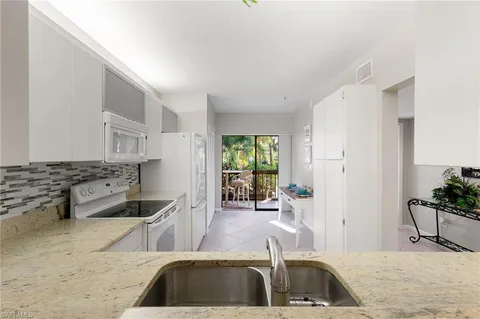 a kitchen with granite countertop a sink and a stove top oven
