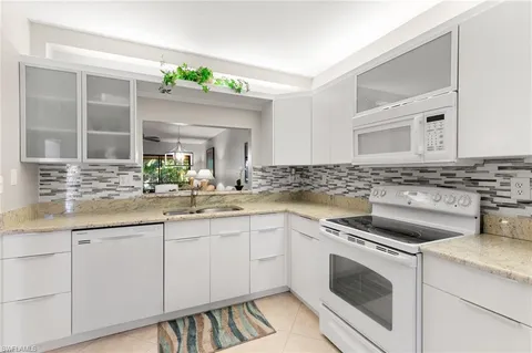 a kitchen with granite countertop a sink stainless steel appliances and cabinets