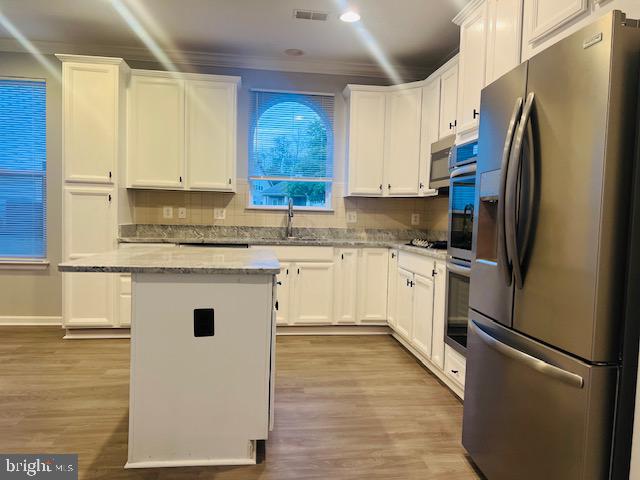 3135 Floating Leaf Lane Waldorf, MD 20603 - Photo 17 of 100 a kitchen with stainless steel appliances granite countertop a refrigerator a sink dishwasher a stove with white cabinets and wooden floor