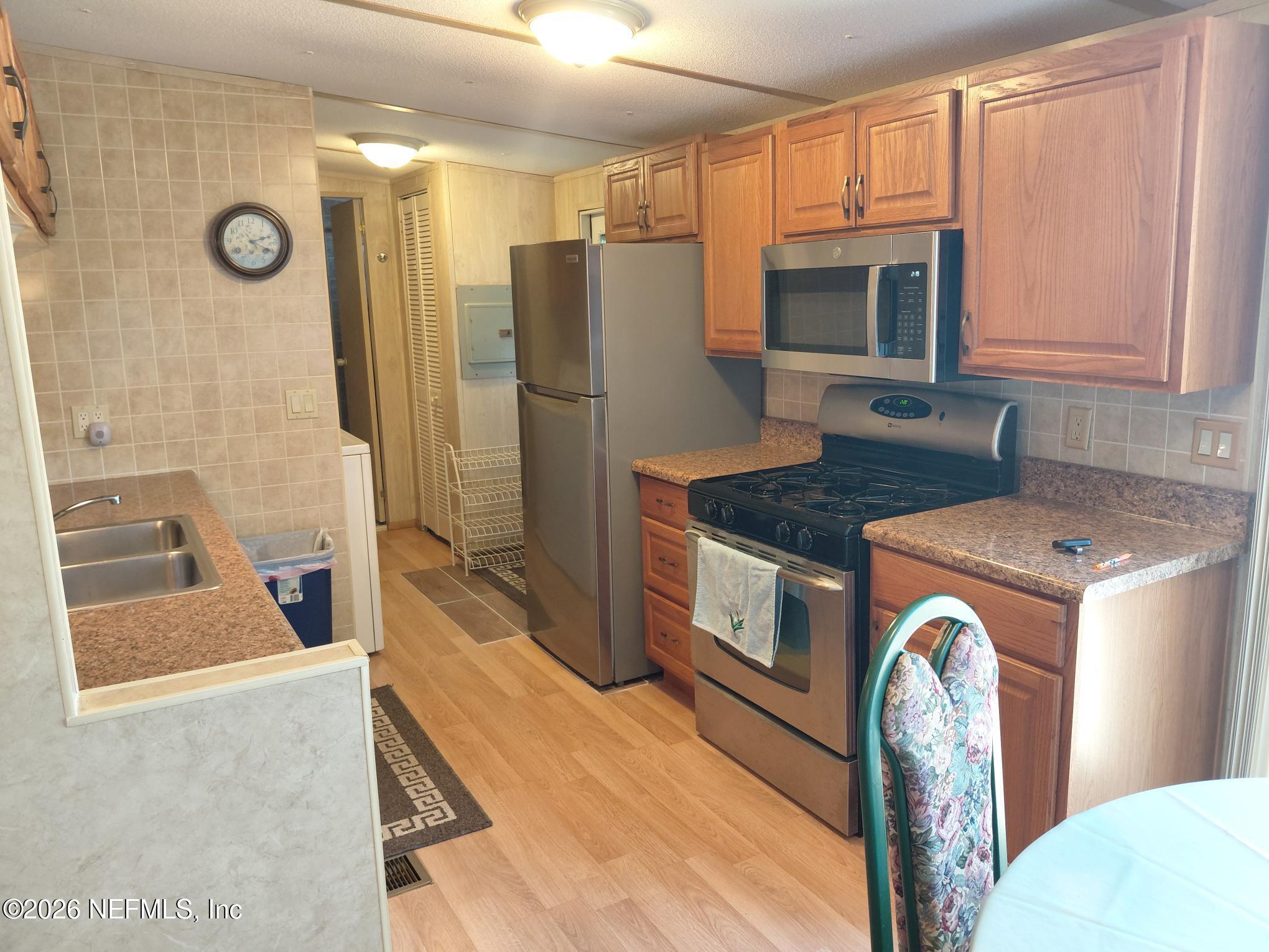 147 Jaffa Road Crescent City, FL 32112 - Photo 11 of 19 a kitchen with stainless steel appliances granite countertop a refrigerator and a stove top oven
