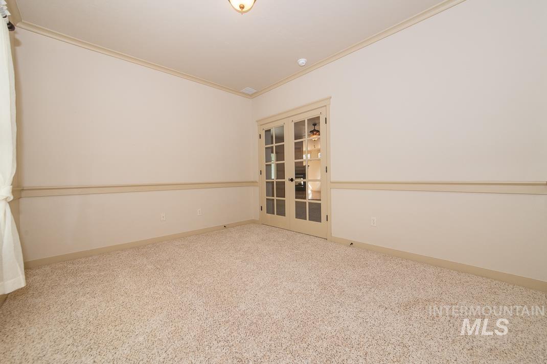 727 West Sedgewick Street Meridian, ID 83646 - Photo 17 of 30 Spare room featuring crown molding, french doors, and carpet flooring