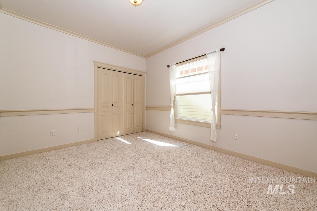 727 West Sedgewick Street Meridian, ID 83646 - Photo 18 of 30 Unfurnished bedroom featuring crown molding, light colored carpet, and a closet