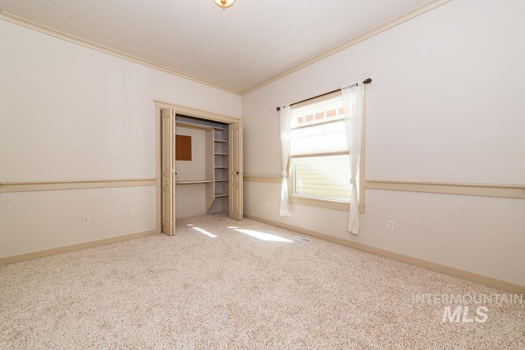 727 West Sedgewick Street Meridian, ID 83646 - Photo 19 of 30 Unfurnished bedroom featuring ornamental molding, light carpet, and a closet