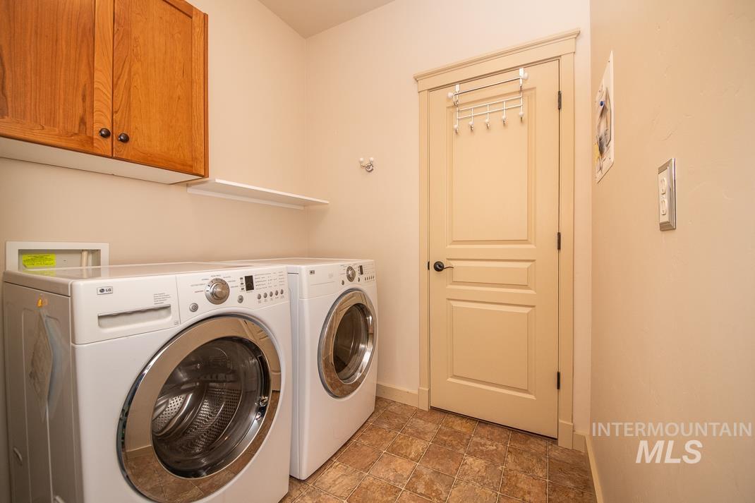 727 West Sedgewick Street Meridian, ID 83646 - Photo 20 of 30 Laundry room featuring stone finish flooring, washing machine and clothes dryer, and cabinet space