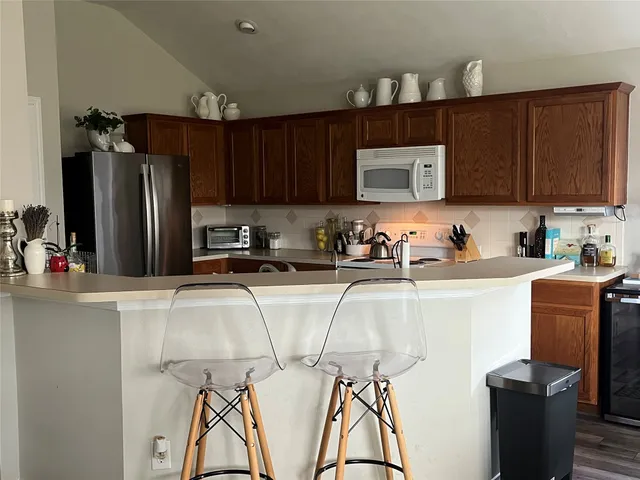 a kitchen with stainless steel appliances granite countertop a refrigerator and stove