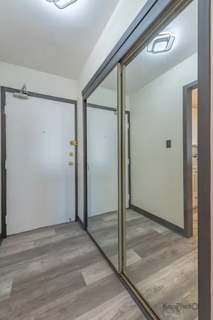 an empty room with wooden floor and mirror