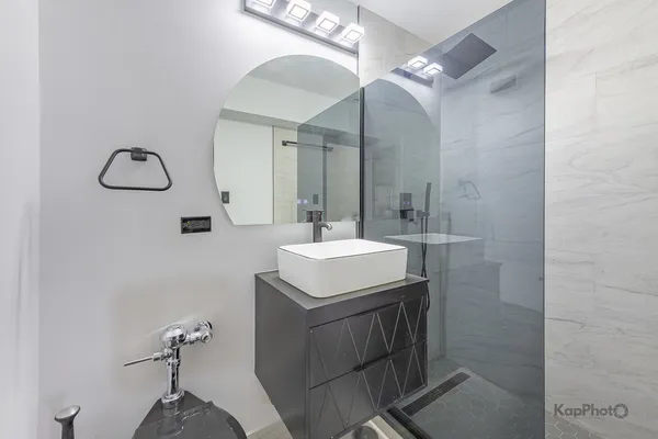 a bathroom with a sink a light fixture and a mirror