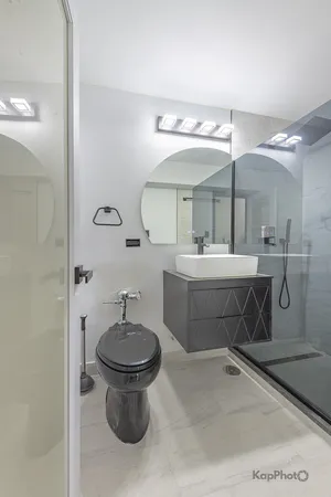 a bathroom with a sink a toilet and a mirror