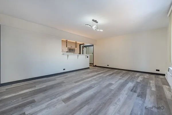 a view of a livingroom with wooden floor and ceiling fan