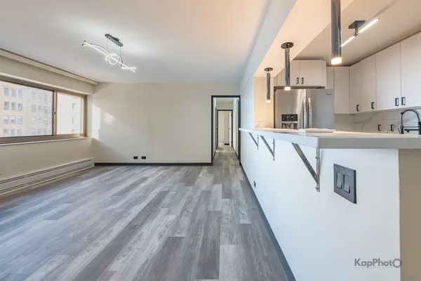 a large white kitchen with wooden floor