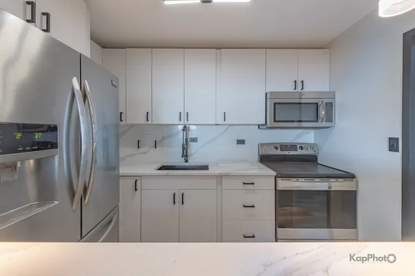 a kitchen with stainless steel appliances granite countertop a stove a refrigerator and a sink