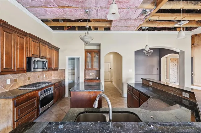 a view of an empty room with a chandelier fan