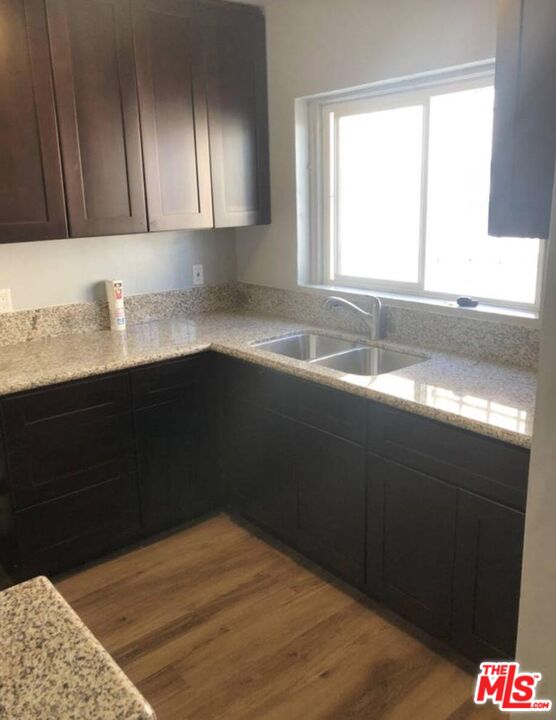 1229 West 36th Place Los Angeles, CA 90007 - Photo 3 of 8 a kitchen with granite countertop a sink and a window