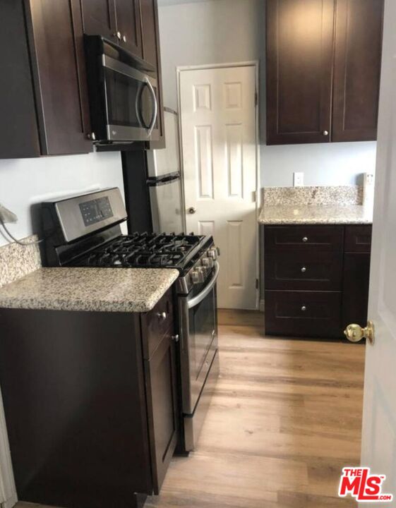 1229 West 36th Place Los Angeles, CA 90007 - Photo 5 of 8 a kitchen with stainless steel appliances granite countertop a stove a sink and a microwave