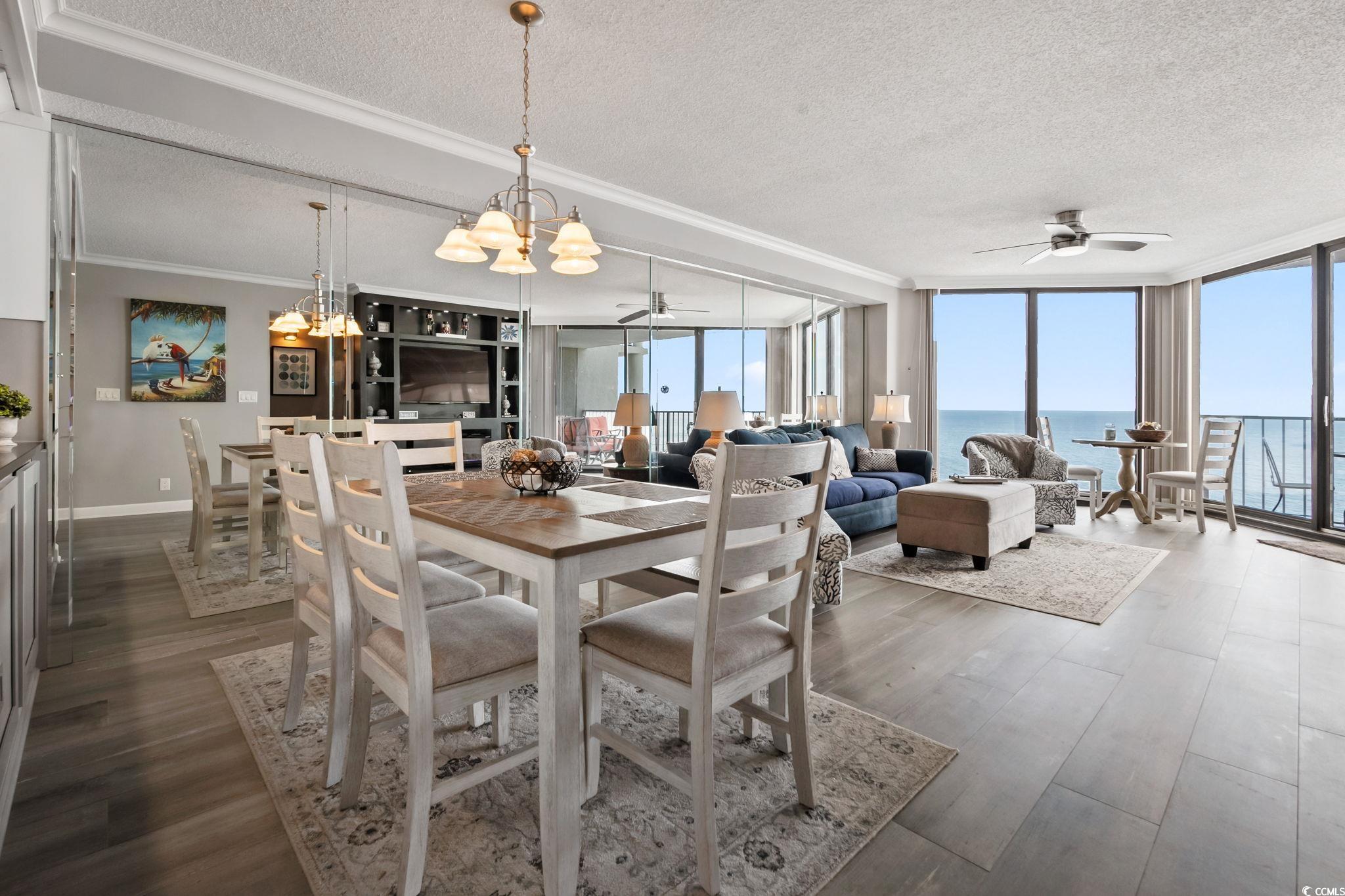 1990 North Waccamaw Drive, Unit 403 Murrells Inlet, SC 29576 - Photo 12 of 39 Dining space with a wall of windows, a textured ceiling, healthy amount of natural light, a ceiling fan, and dark wood finished floors