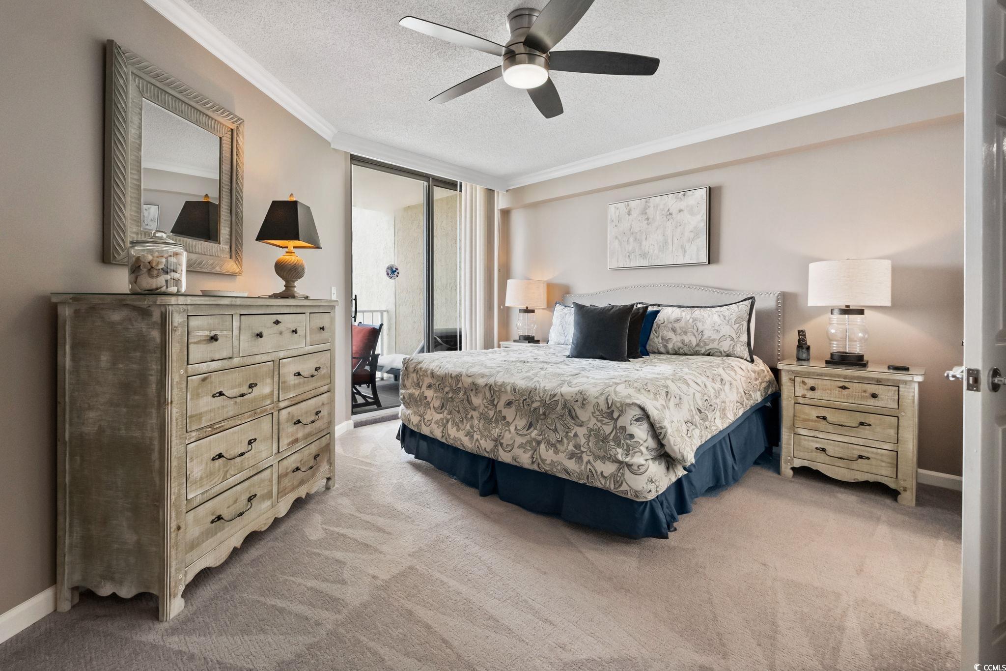 1990 North Waccamaw Drive, Unit 403 Murrells Inlet, SC 29576 - Photo 16 of 39 Bedroom with a textured ceiling, ornamental molding, light colored carpet, a ceiling fan, and a wall of windows