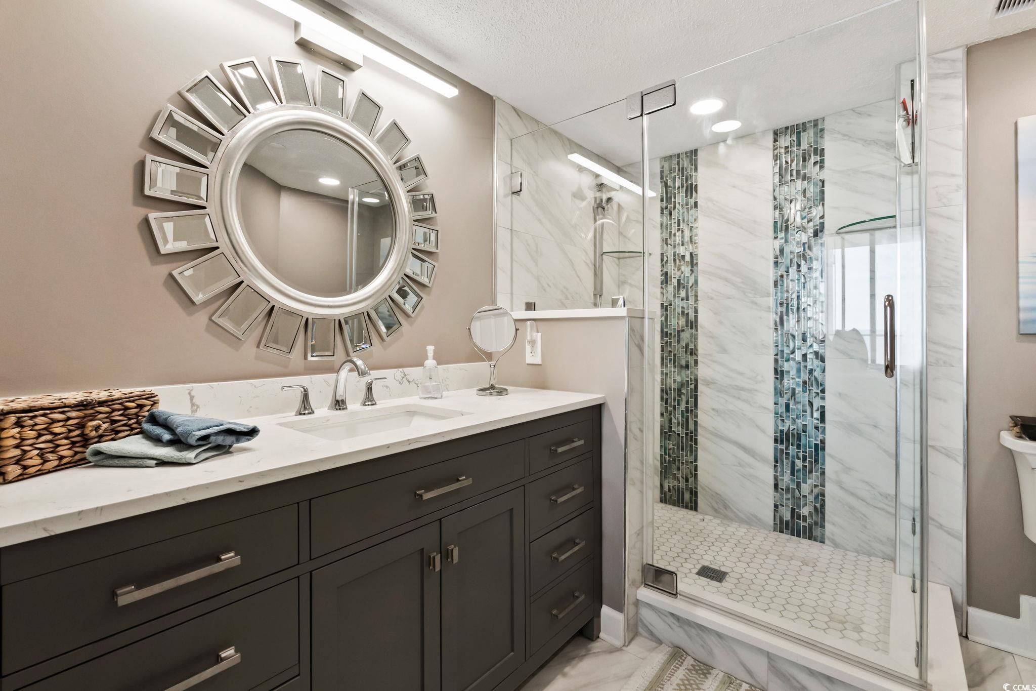 1990 North Waccamaw Drive, Unit 403 Murrells Inlet, SC 29576 - Photo 17 of 39 Bathroom featuring vanity, a stall shower, and light marble finish floors