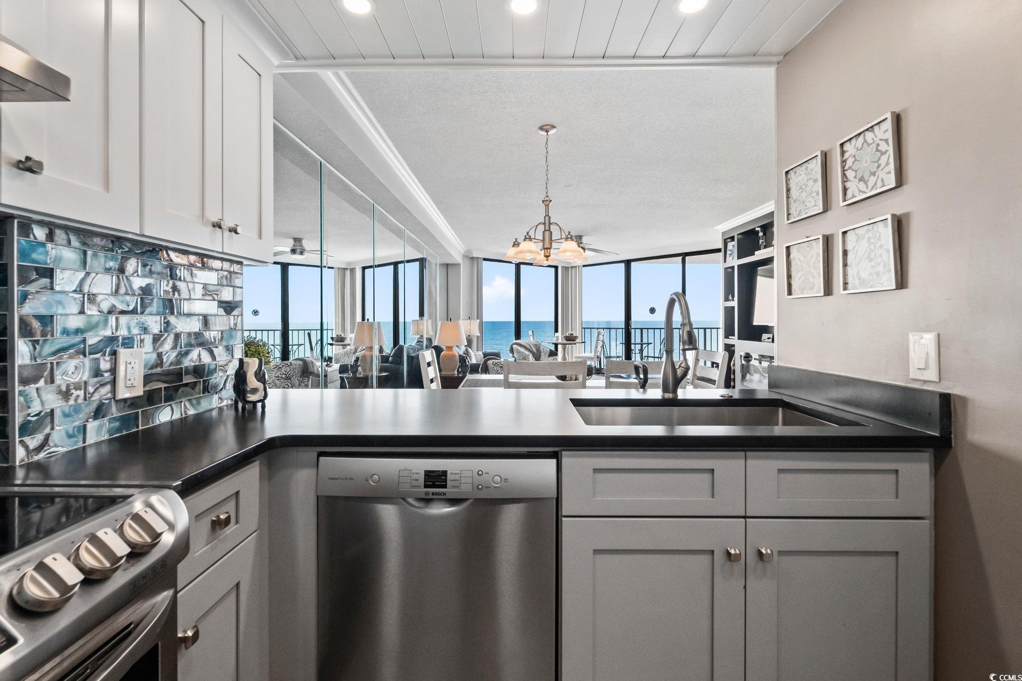 1990 North Waccamaw Drive, Unit 403 Murrells Inlet, SC 29576 - Photo 38 of 39 Kitchen with dark countertops, appliances with stainless steel finishes, open floor plan, a chandelier, and gray cabinets