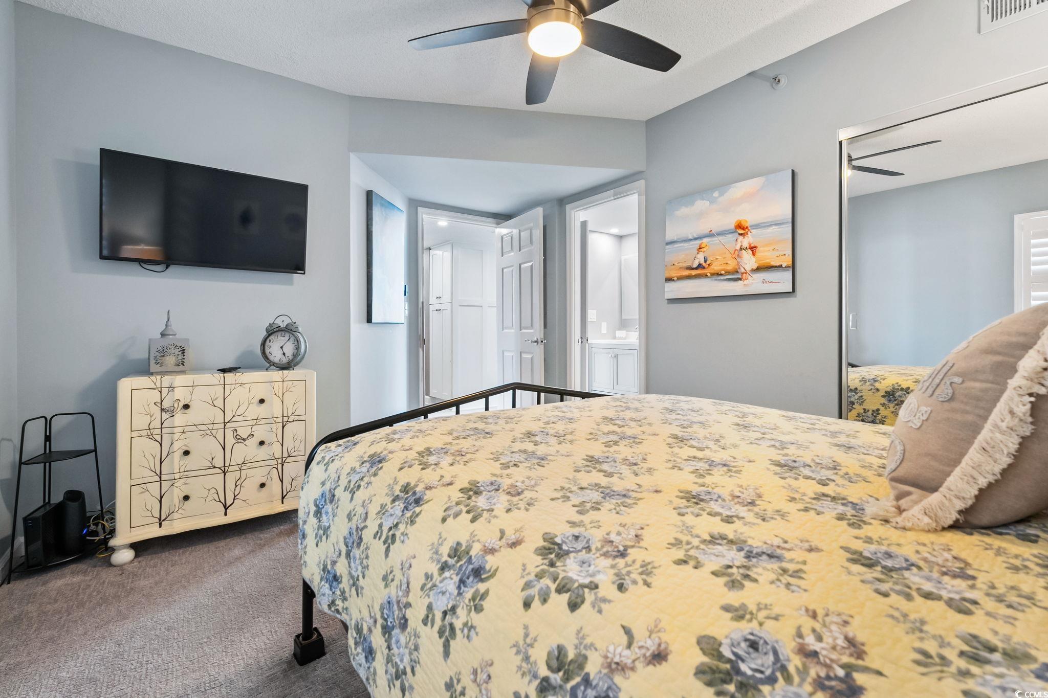 1990 North Waccamaw Drive, Unit 403 Murrells Inlet, SC 29576 - Photo 25 of 39 Bedroom featuring dark carpet, a ceiling fan, and connected bathroom